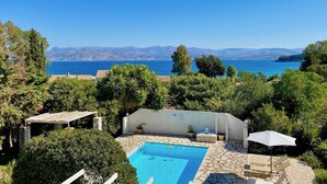 Ein Poolbereich mit Blick auf das Meer und die Berge.