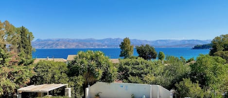 Un espace piscine offrant une vue sur la mer et les montagnes.
