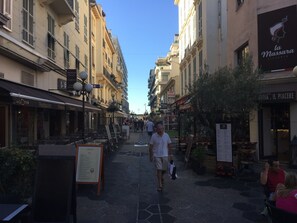 A narrow street lined with cafes and restaurants, including 'la Massara Pizzeria'. - Stunning apartment in the Gold Square of Nice! (Nice)