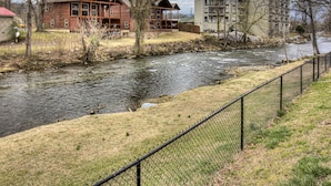 Une vue sur la rivière, avec une cabane en bois et un immeuble à plusieurs étages.