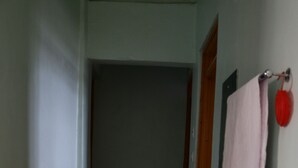 A narrow hallway leading to a bathroom with a sink and a mirror. - Home away from home (Nyeri)