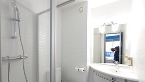 A modern bathroom with a glass shower enclosure, a toilet, and a sink with a mirror above it. - Greet Hotel Grenoble Centre Gare (Grenoble)