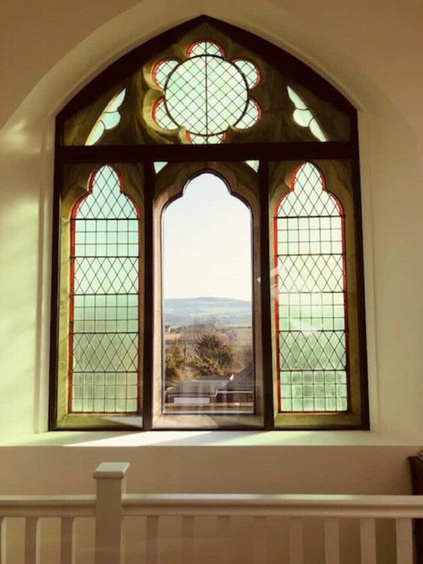 A stained glass window with a symmetrical design and a view of a landscape.