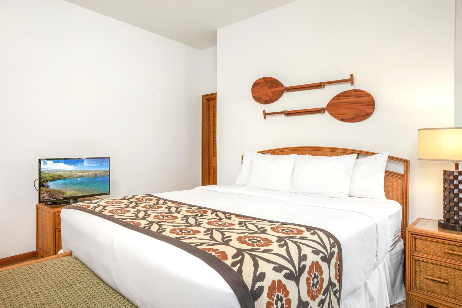 Ein Hotelzimmer mit Bett, Fernseher, Lampe und einem Wandinstrument.