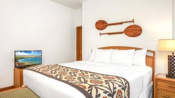 Ein Hotelzimmer mit Bett, Fernseher, Lampe und einem Wandinstrument.