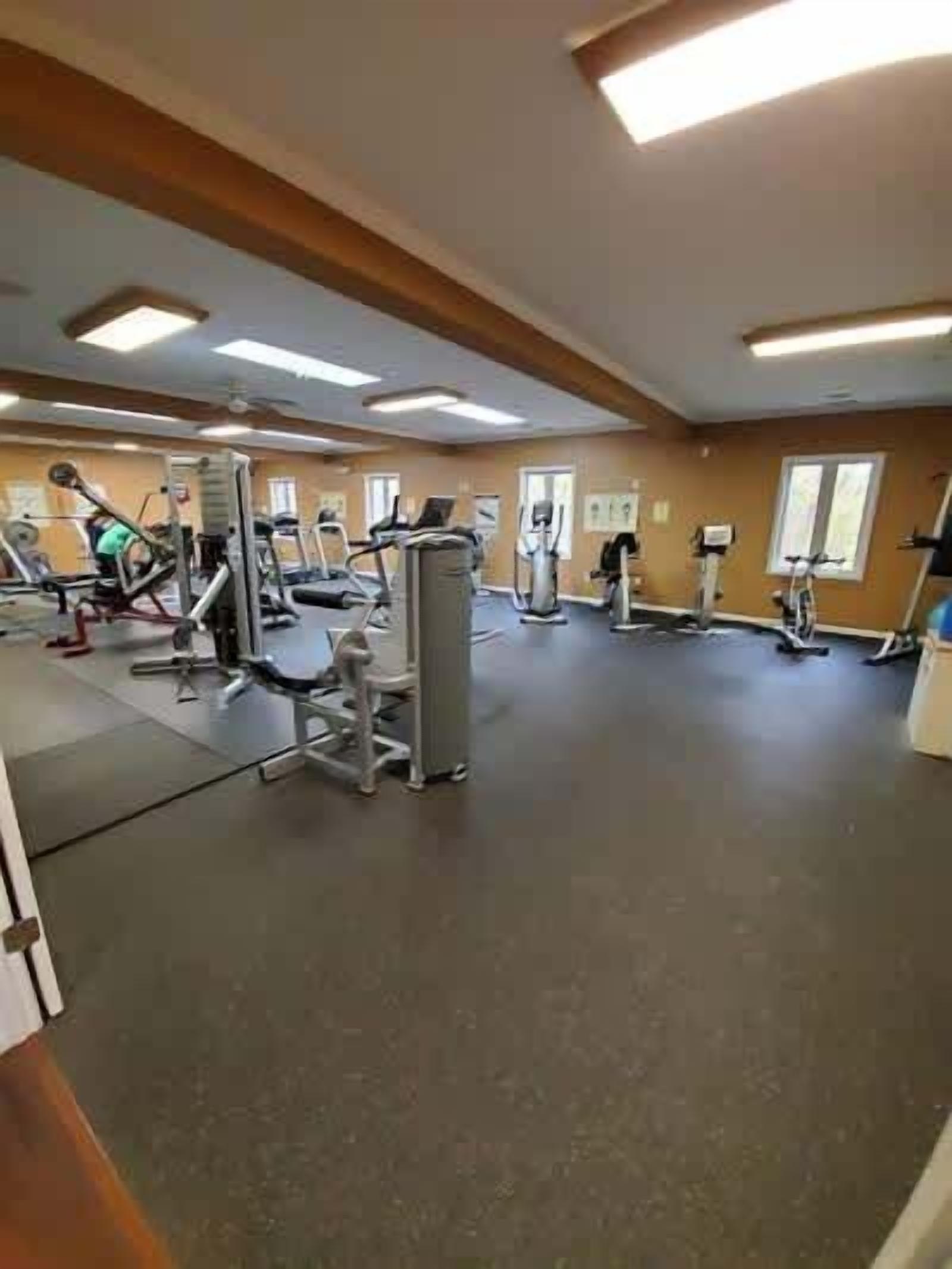 A gym with various exercise equipment, including treadmills and weight machines.