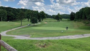A golf course with a clear sky, lush green grass, and trees in the background. - A place to unwind!! (Kansas)