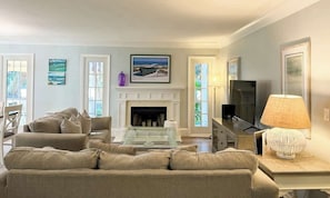 A living room with a fireplace, a sofa, a coffee table, and a television.