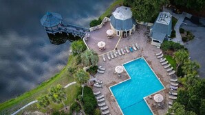 An aerial view of a resort with a swimming pool, lounge chairs, and a water slide.