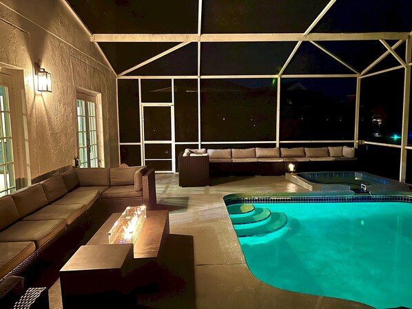 Un área de piscina al aire libre con un jacuzzi, un sofá y una mesa.