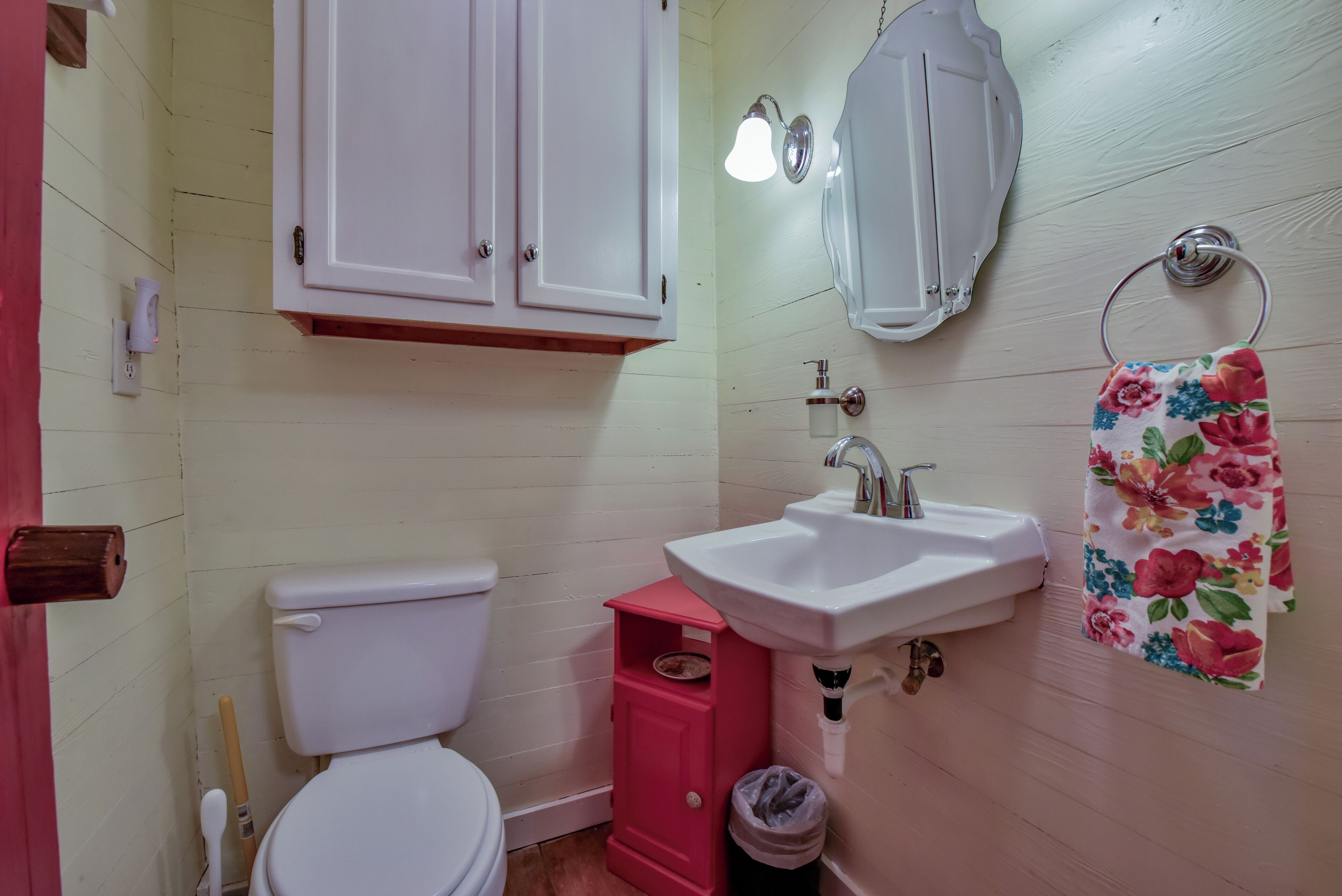 Un baño con inodoro, lavamanos, espejo y mueble.