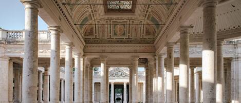 A grand hall with a high ceiling, large columns, and a central open space.