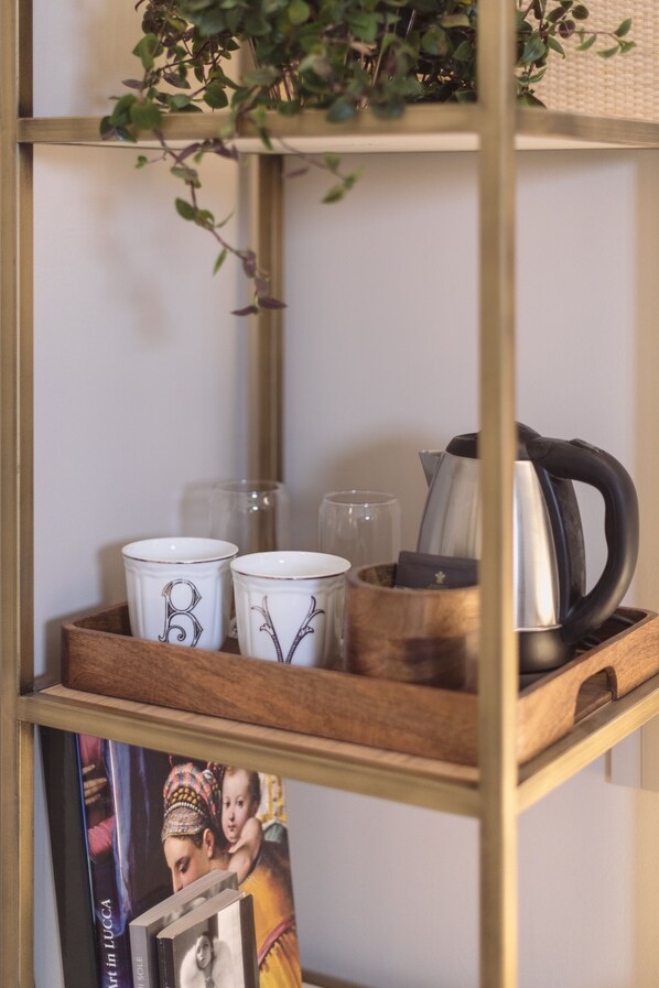 Una estantería con objetos decorativos como tazas, vasos y una tetera.