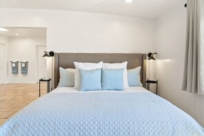A hotel room with a large bed, two bedside tables, and a headboard.