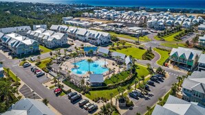 Vista aérea de un resort con varias construcciones, una piscina central y vista al océano.