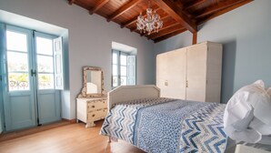 A bedroom with a bed, a wardrobe, a dresser, and a mirror. - Vintage Cottage With Large Yard (Cerezal de Peñahorcada)