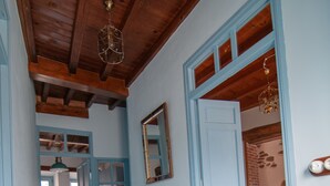 A hallway with a patterned floor, a white table, and blue doors. - Vintage Cottage With Large Yard (Cerezal de Peñahorcada)