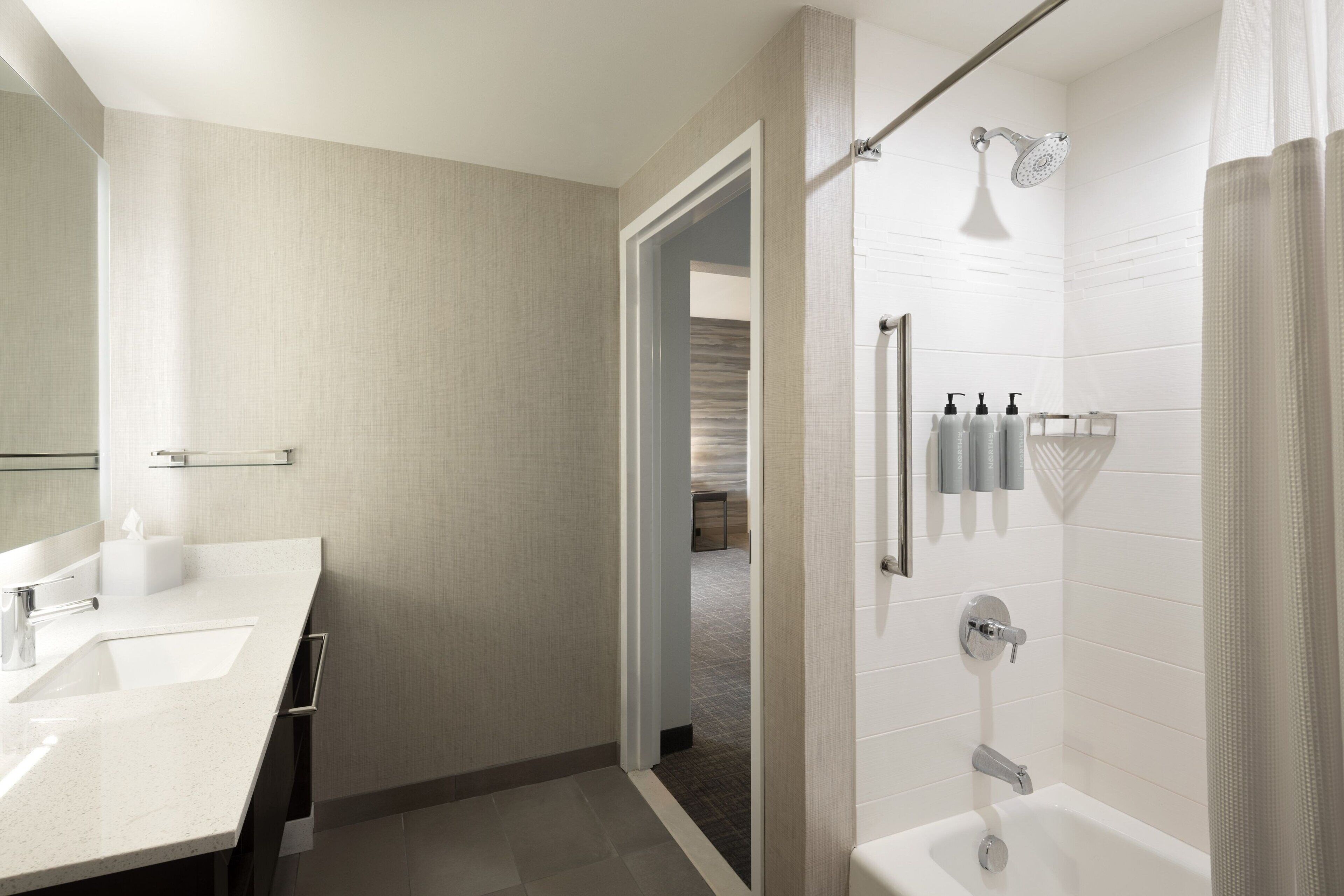Un baño moderno con lavamanos doble, ducha e inodoro.
