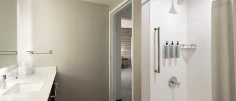 Un baño moderno con lavamanos doble, ducha e inodoro.