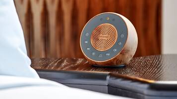 A wooden speaker with a circular design on a table.