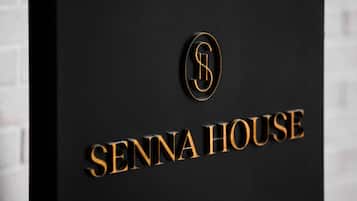 A sign with the text "SENNA HOUSE" and a logo above it.