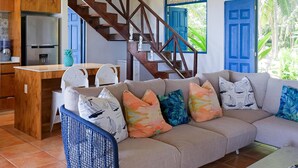 A spacious living area with a sofa, a coffee table, and a kitchen area with a refrigerator.