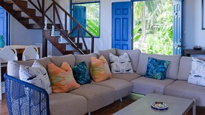 A living room with a sofa, a coffee table, and a staircase.