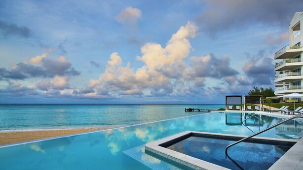 A pool with a view of the ocean and a building with balconies. - The Residences at The St. Regis Bermuda (Town of St. George)