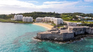 A coastal resort with multiple white buildings, a beach, and a fortified structure. - The Residences at The St. Regis Bermuda (Town of St. George)