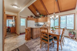 A spacious kitchen with wooden cabinets, a central island, and a dining area with a wooden table and chairs. - 1176 Wolfscratch Dr, 609 Petit Crest Villas, Big Canoe, GA, 30143, US (Big Canoe)