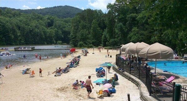 A beach with a pool, umbrellas, and people. - 1176 Wolfscratch Dr, 609 Petit Crest Villas, Big Canoe, GA, 30143, US (Big Canoe)