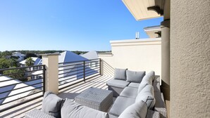 Une terrasse sur le toit, aménagée avec un ensemble de canapés, une petite table et une rambarde.