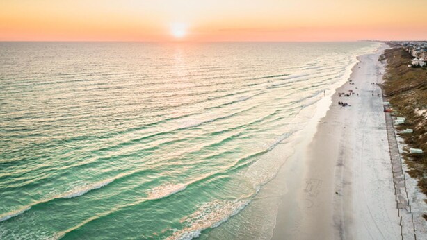 Une vue sur la côte, avec une plage et l’océan au coucher du soleil.
