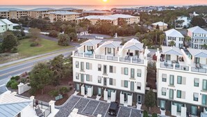 Un hôtel situé sur la côte, composé de plusieurs bâtiments, doté d’un parking et offrant une vue sur le coucher de soleil sur l’océan.