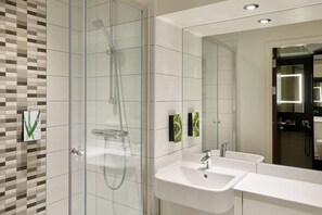 A modern bathroom with a glass-enclosed shower, a white sink, and a large mirror. - Premier Inn Blackpool (Blackpool)