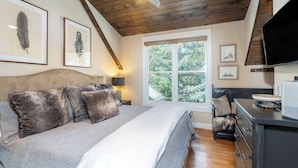 A bedroom with a bed, wooden ceiling, ceiling fan, window, and a dresser. - Main Street Tri-plex close to everything! (Telluride)