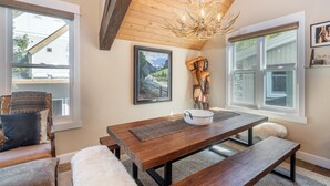 A dining area with a wooden table, benches, and a chandelier. - Main Street Tri-plex close to everything! (Telluride)
