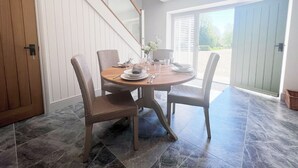 A dining area with a round table, four chairs, and a staircase leading to an upper floor. - The Old Stables 2 - UK35616 (Winterslow, near Salisbury)