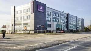 En modern hotellbyggnad med en tydlig skylt för Premier Inn, flera våningar och en väl synlig restaurangskylt.