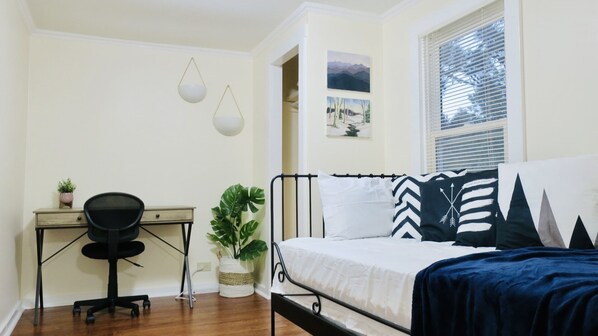 A bedroom with a bed, a desk, a chair, a potted plant, and a window with blinds. - Cozy Home, Minutes from Killington! Washer/Dryer & Free Disney+/Peacock! (Mendon)
