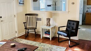 A living room with a wooden coffee table, two chairs, a rug, and a small side table with a lamp. - Cozy Home, Minutes from Killington! Washer/Dryer & Free Disney+/Peacock! (Mendon)