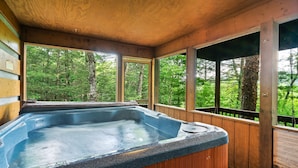 A hot tub in a wooden cabin with large windows overlooking a forest. - Spring Break! Games~Secluded & Close~Nerf~Foosball~HotTub~One Step Entry (sevierville)
