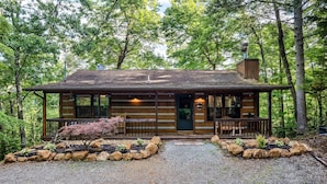 A rustic cabin with a wooden exterior, a front porch, and a stone pathway leading to the entrance. - Spring Break! Games~Secluded & Close~Nerf~Foosball~HotTub~One Step Entry (sevierville)