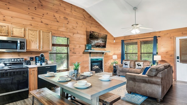 A cozy cabin-style interior with a kitchen, dining area, and living room. - Spring Break! Games~Secluded & Close~Nerf~Foosball~HotTub~One Step Entry (sevierville)