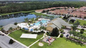 Un resort con una grande piscina, diversi edifici e un'area parcheggio.