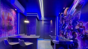 Una stanza con tavolo da biliardo, angolo bar e un murale raffigurante una scena cinematografica.