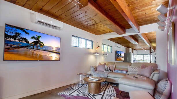 A modern living room with a large flat-screen TV, a sofa, a coffee table, and a patterned rug. - The Agave House | Mountain Views & Pool (La Mesa)