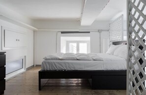 A bedroom with a bed, a wardrobe, and a window.