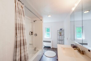 Un bagno moderno dotato di vasca, doccia, WC e lavabo.