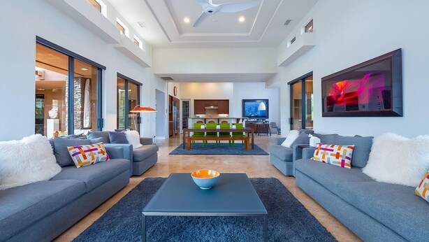 A modern living room with two grey sofas, a coffee table, and a dining area in the background. - Luxury Modern Oasis w/ Salt Pool, Spa & Zen Yard (Rancho Mirage)
